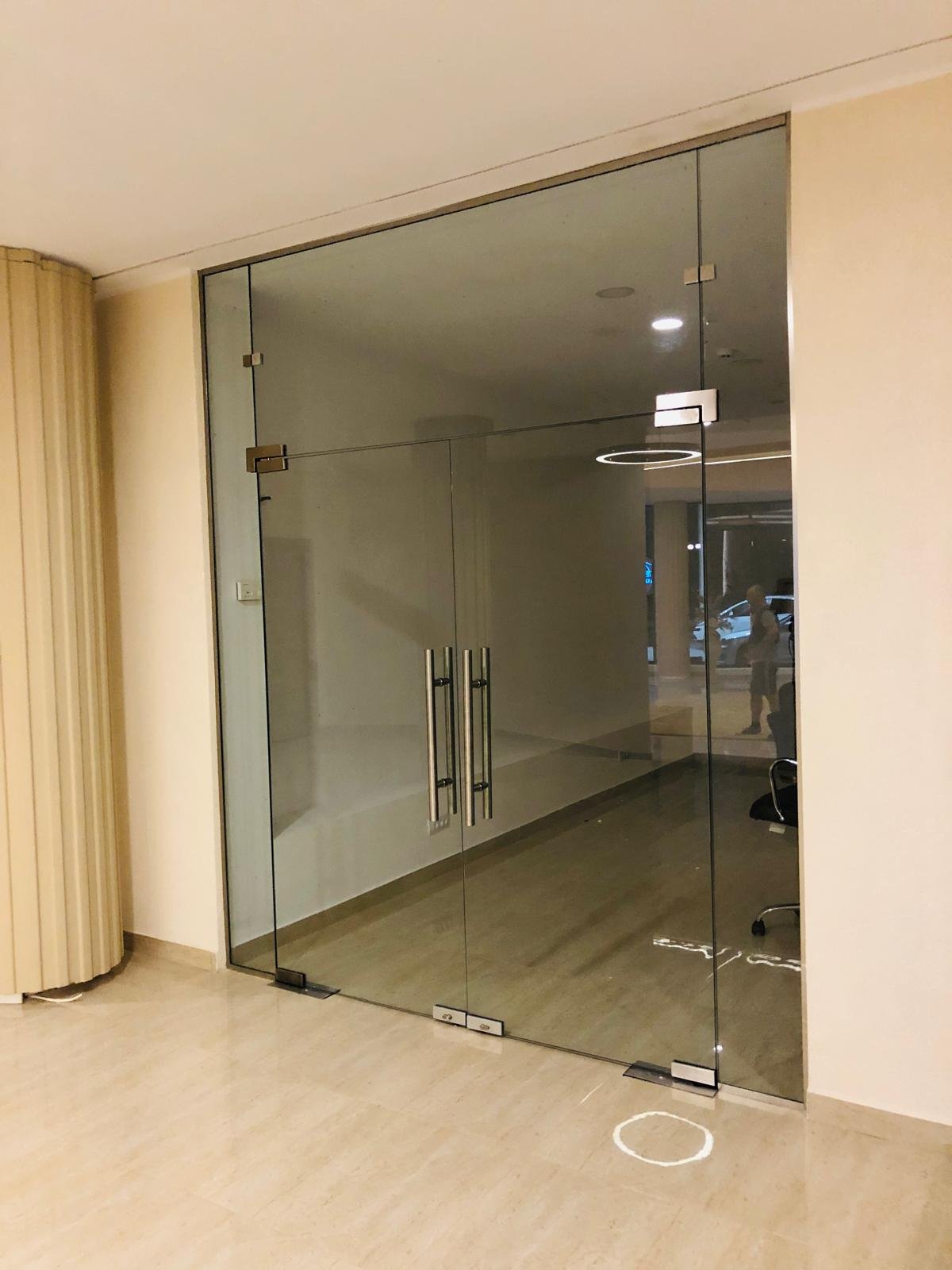 Detaliu feronerie premium italiană pentru ușă din sticlă cu finisaj auriu periat
